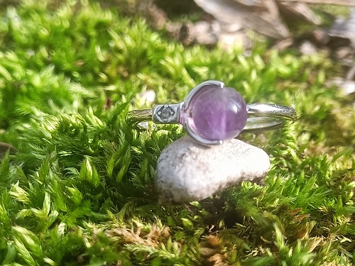 Bague réglable, fermée, en argent sterling 925 et pierre améthyste de 6 mm. L’améthyste est considérée comme la pierre de l'humilité et la pierre de la sagesse. Elle stimule la créativité, l'imagination et la clarté. L'argent rajoute l'assurance et la confiance en Soi... Plus précisement : Bienfaits de l'améthyste sur le plan mental, physique et spirituel : Vertus et propriétés de l’améthyste sur le plan mental En lithothérapie, l’améthyste est considérée comme la pierre de l’humilité et la pierre de la sagesse. Elle stimule la créativité, l’imagination et la clarté. Cette pierre joue un grand rôle et favorise non seulement la méditation, la concentration, mais aussi l’élévation spirituelle. Elle se charge aussi d’apaiser la colère, la peur, les inquiétudes, les angoisses, la tristesse et le chagrin. D’un point de vue psychologique, elle aide à lutter contre les addictions liées à la drogue, à l’alcool ou au tabac et elle peut même aider les personnes souffrant de Troubles Obsessionnels Compulsifs (TOC) à apaiser leur quotidien. L’ améthyste a par ailleurs pour propriété d’être une pierre de passage et d’être une variété qui comprend la séparation. Elle peut être utilisée en cas de perte d’un proche, aussi bien pour celui qui s’en va que pour celui qui reste. Une propriété remarquable et une vertu des gemmes améthyste sont de purifier les lieux et les objets, que ce soit par le biais d’une boule améthyste ou encore sous une autre forme. Elle purifie le corps physique, mais aussi l’aura. Elle accepte et intègre parfaitement les nouveautés, les changements. Elle sert également à nettoyer, purifier et recharger les autres pierres et minéraux. L’idéal est de procéder à cette purification sur un tapis d’améthyste ou une géode d’améthyste. Plus la taille de la géode est importante, et plus la purification sera efficace. Il faut cependant veiller à ce que l’améthyste ne change pas de couleurs auquel cas, cela peut signer que le minéral est aussi en mauvaise santé. Toujours dans le cadre d’une purification d’un lieu, la gemme améthyste contribue à la paix et à la relaxation, elle aide celui qui la porte en bracelet ou collier, mais pas que. Elle permet de procurer le calme et la détente profonde si elle est dans une chambre. Si elle est dans votre salon, cette pierre pourra augmenter le taux énergétique de la pièce en question. Si vous privilégiez un bracelet de gemmes améthyste, celui-ci vous accompagnera et vous offrira tous les pouvoirs qu’offre l’améthyste. Vous profiterez pleinement des propriétés de calme et d’apaisement qu’il procure, tout au long de la journée dès lors que vous le porterez. En bracelet, il est possible de le porter en perles de 6mm, allant jusque 14mm voir plus. Sous forme de pendentif, il sera directement posé sur votre chakra plexus solaire mais il faut veiller qu’il soit au contact direct de la peau, c’est l’idéal en lithothérapie. Vertus et propriétés de la l’améthyste sur le plan physique Sur le plan physique, l’énergie relaxante de l’améthyste permet de soulager l’hypertension et les douleurs musculaires. Elle est particulièrement efficace pour libérer les tensions au niveau du haut du dos, de la nuque et des épaules. En rééquilibrant l’aura, elle permet de trouver le calme avant de dormir. Ainsi, vous pouvez la poser sur votre table de chevet ou sous votre oreiller pour bénéficier d’un sommeil profond et réparateur, mais aussi pour faire de beaux rêves. Ses vibrations douces et réconfortantes peuvent convenir aux adultes, aux enfants et même aux animaux. En plus de calmer l’hyperactivité, l’améthyste est un minéral qui protège la mémoire, le cœur et les voies respiratoires. En période de convalescence, elle accélère le processus de cicatrisation et de guérison. Sous forme de collier par exemple, elle peut aider à soulager les maux de tête et à combattre toutes les formes d’addiction. D’ailleurs, elle est fortement recommandée pour faciliter l’élimination des toxines du corps. Idéale pour les femmes, les cristaux d’améthyste stimule la fertilité, la production d’hormones et les glandes endocriniennes. Ce quartz féminin favorise également l’harmonisation des cycles menstruels. Les gems d’améthyste sont considérées comme les pierres d’apaisement par excellence. Une chose est sûre ; cette agréable sensation de bien-être n’aura que des répercussions positives sur votre corps et votre esprit. Certains l’utilisent pour accélérer le processus de cicatrisation, notamment dans le cas de brûlures. Vertus et propriétés de la l’améthyste sur le plan spirituel Sur le plan spirituel, ces gems sont associées au septième chakra, également appelé le chakra coronal. Centre de la sagesse et de la connaissance, le chakra coronal permet d’ouvrir votre esprit et d’accéder à un tout autre niveau de conscience spirituelle. Ainsi, porter une améthyste sous forme de pendentif par exemple, permet d’acquérir de nouvelles connaissances et de faire tomber toutes les barrières mentales. Grâce à cette puissante pierre de couleur violette, votre esprit s’apaise, vos peurs se dissipent et les pensées positives fleurissent. Généralement, ce sont vos attachements terrestres qui bloquent le chakra coronal. Si vous avez tendance à être trop terre-à-terre et que vous n’arrivez pas à lâcher prise, garder un quartz améthyste près de vous peut vous aider à prendre du recul, à faire le vide et à écouter cette petite voix intérieure qui vous guide au quotidien ; il s’agit de votre intuition, et bien souvent, elle ne se trompe pas. En ouvrant le chakra coronal, l’améthyste permet de retrouver l’inspiration, la créativité, l’imagination et l’esprit novateur qui sommeillent en vous. L'argent apporte assurance et confiance en soi. Sur le plan physique, il est anti-inflammatoire et renforce le système immunitaire Purification dans de l’eau distillée non salée, et recharge à la lumière de la lune si possible sur un amas de quartz.