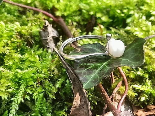 Bague réglable en argent sterling 925 et perle d'eau douce sur socle de nacre Symbole fascinant par sa beauté, et doté d'une puissance mystérieuse et créatrice, cette perle est l'attribut des grandes divinités antiques de la fertilité. Dans la symbolique chrétienne, elle est devenue l'emblème du Christ et de sa naissance virginale, et la plus parfaite évocation du royaume des cieux. La perle est douce, tendre et féminine. Comme la nacre, elle procurerait apaisement et bien-être. Elle aurait des effets positifs sur les problèmes de décalcification. Il y a des siècles, on l’utilisait déjà pour soigner la démence et l’épilepsie, ainsi que la dépression. En Inde on lui prêtait des bienfaits multiples, notamment contre la phtisie, les problèmes ophtalmologiques, les hémorragies... La médecine hindoue l’utilise toujours, en poudre, pour raviver l’énergie, en particulier sexuelle. En Orient, on lui attribue des vertus en lien avec la fécondité et un caractère aphrodisiaque. Fusion de l'animal et du minéral, la perle possède des vertus stimulantes et tonifiantes. La perle est attractive, tendre et féminine. Sa lumière et ses teintes nacrées, son éclat presque lunaire, en font un gemme apaisant. Elle est donc très souvent utilisée dans le cadre de la relaxation. L'argent apporte assurance et confiance en soi. Sur le plan physique, il est anti-inflammatoire et renforce le système immunitaire Nettoyage à l’eau distillée salée, et purification à la lumière solaire ou lunaire